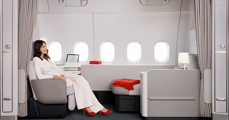 Hôte installée dans la suite La Première d’Air France avec fauteuil et méridienne transformable en lit